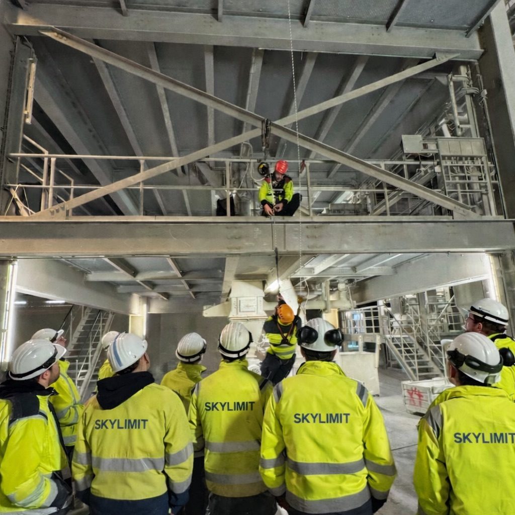 Ausrüstung Kletterausrüstung Seile Karabiner Prüfung DGUV Gelbe Rucksäcke mit Sicherheitsausrüstung und Seilen in einem Outdoor-Umfeld.