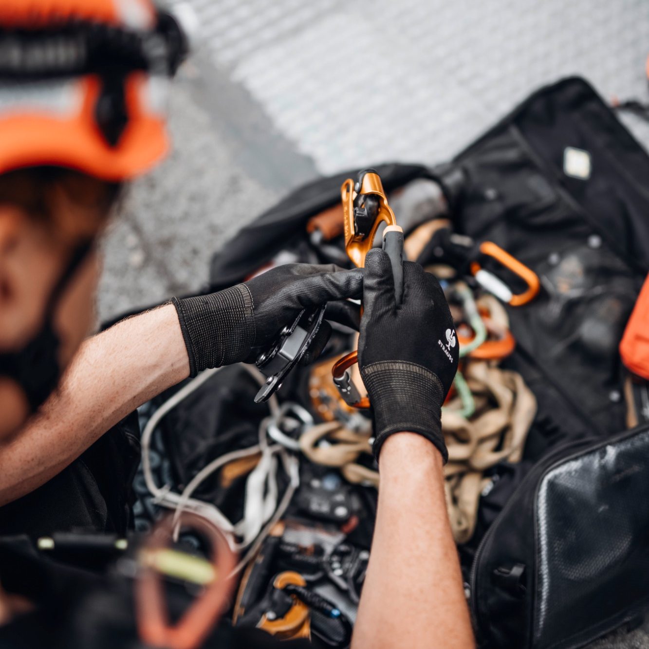 Ausrüstung Kletterausrüstung Seile Karabiner Prüfung DGUV Gelbe Rucksäcke mit Sicherheitsausrüstung und Seilen in einem Outdoor-Umfeld.
